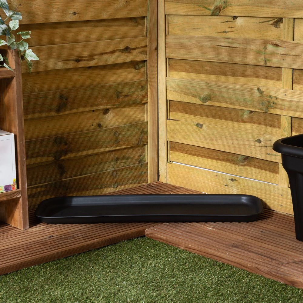 Black tray on a wooden deck with a wooden fence and plant in the background