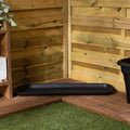 Black tray on a wooden deck with a wooden fence and plant in the background